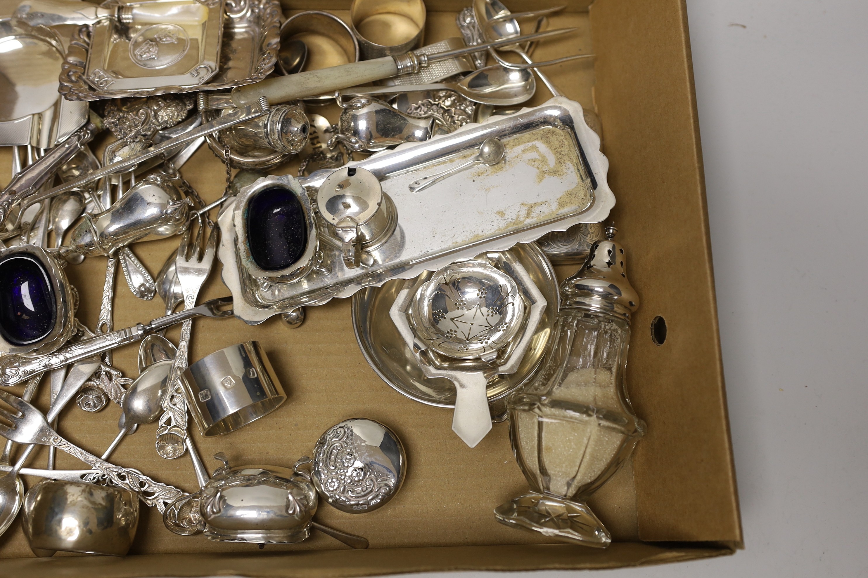 Sundry small silver wares including a cigarette case, two tea strainers, assorted flatware and a condiment set.